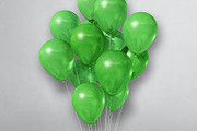 Green balloons bunch on a white wall background | Holiday Stock Photos