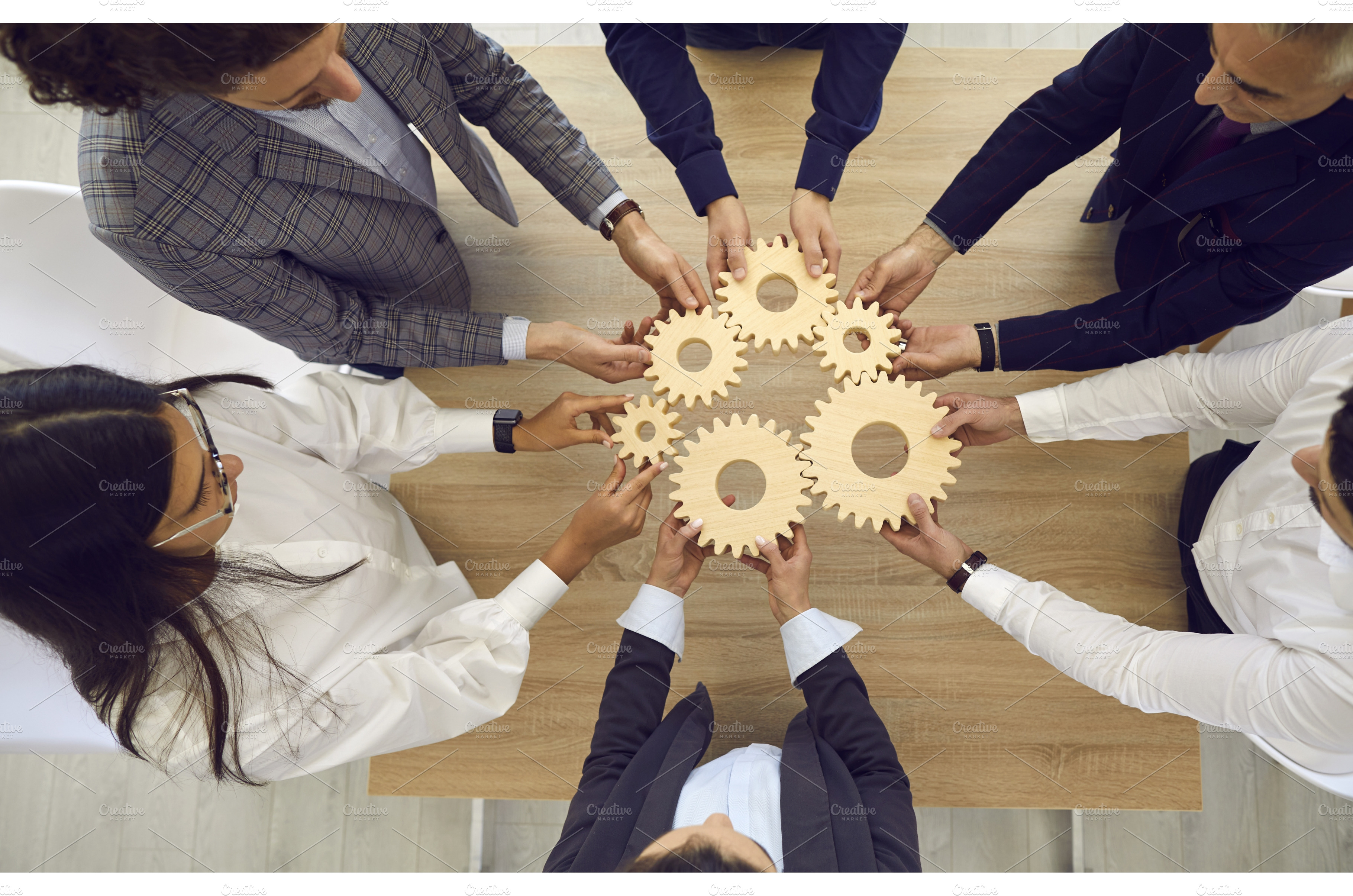 People stacking wooden gears next to | Business Images ~ Creative Market