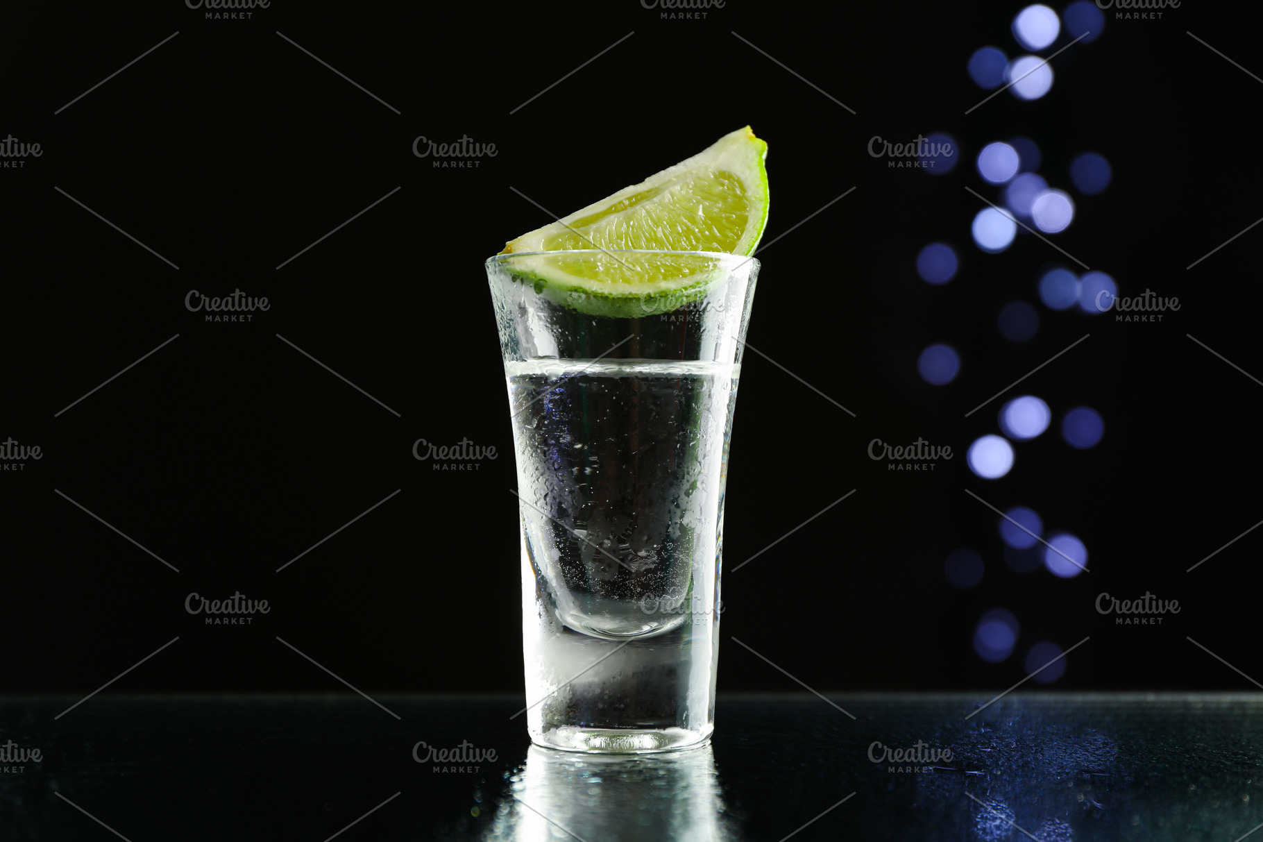 Tequila shot with lime against black background with blurred lig | Food ...