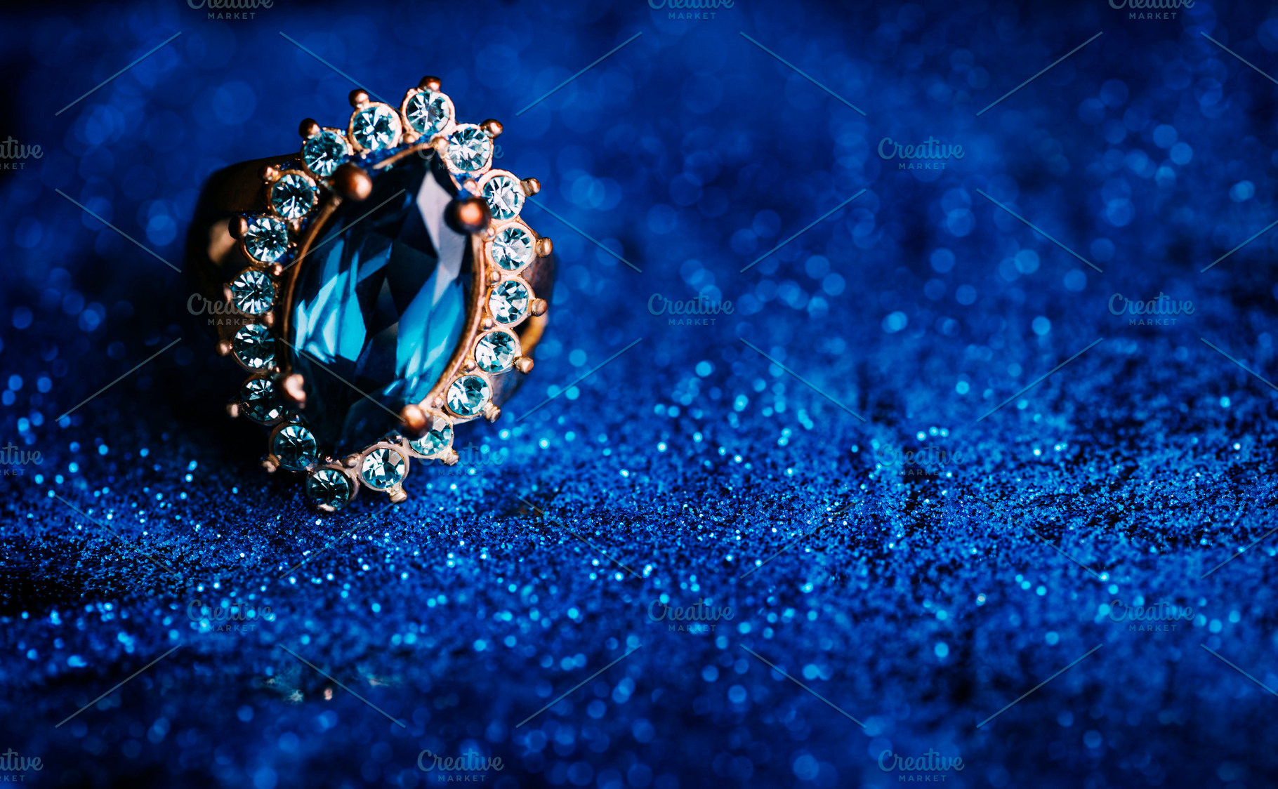 Closeup of luxury wedding ring in dark blue glitter background