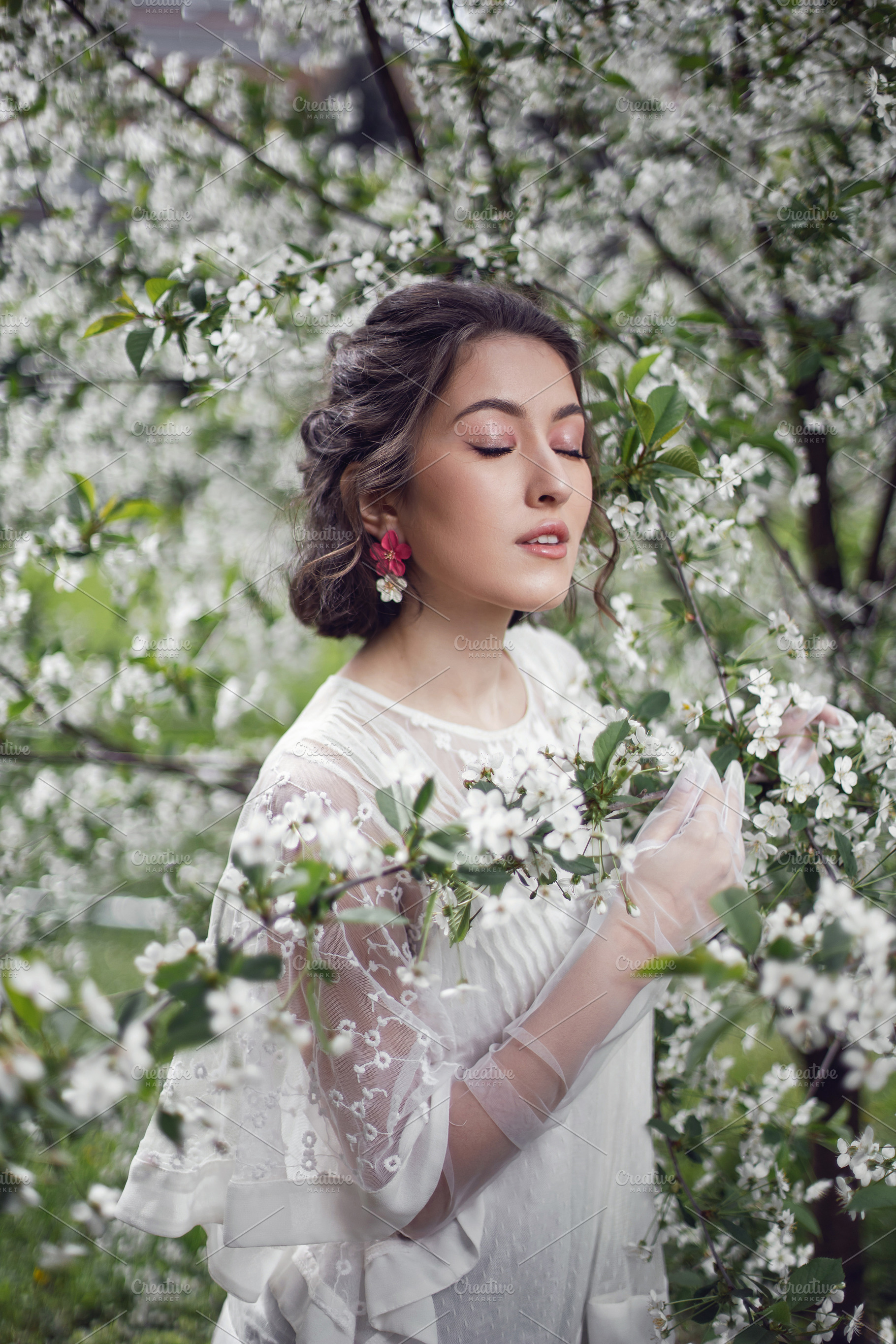 portrait of a young beautiful woman in white clothes standing next to a ...