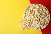 Striped paper cup with popcorn on two tone background | Food Images