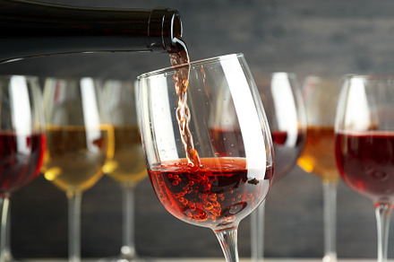 pair of different glass sizes and wines, red and white wine glasses on  wooden furniture table close up selective focus, vineyard farmhouse patio  view Photos