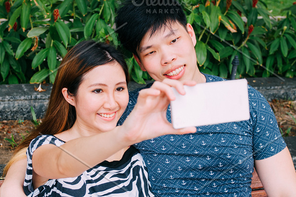 Asian Couple Taking A Selfie Photo In Outdoor Park Scene Love And