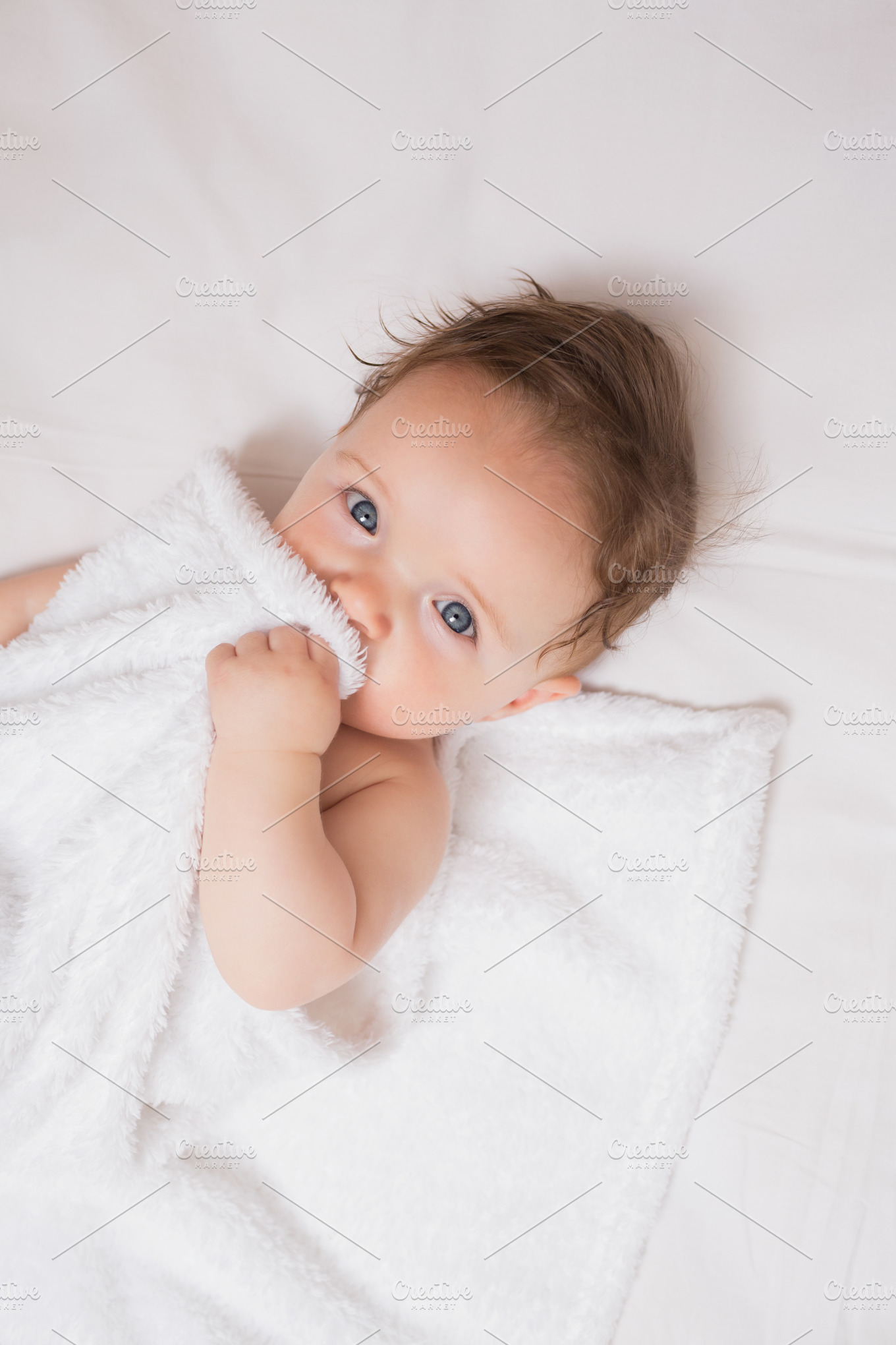 Cute baby holding blanket in crib Stock Photos Creative Market