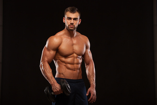 Handsome Power Athletic Man With Dumbbell Is Confidently Looking