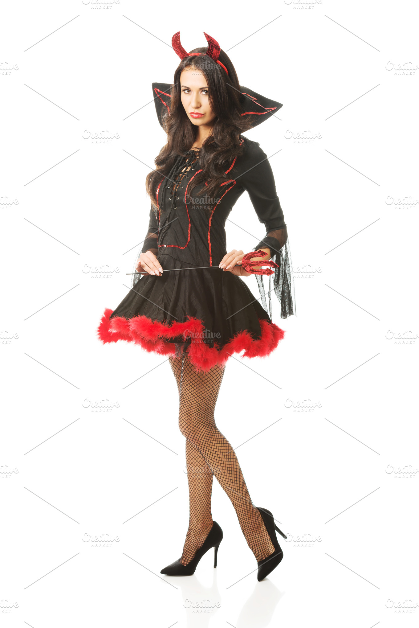 Sexy woman wearing devil clothes, holding trident, looking at the ...