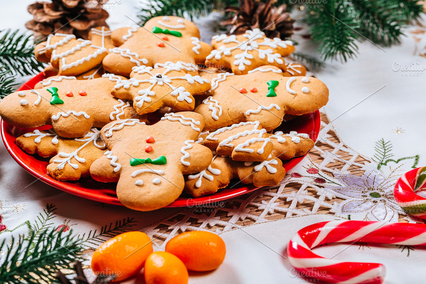 Christmas gingerbread cookies homemade on red plate with branches of