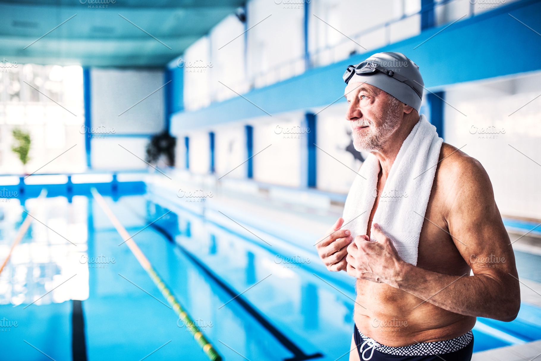 Senior man standing by the indoor swimming pool. | High-Quality Sports ...