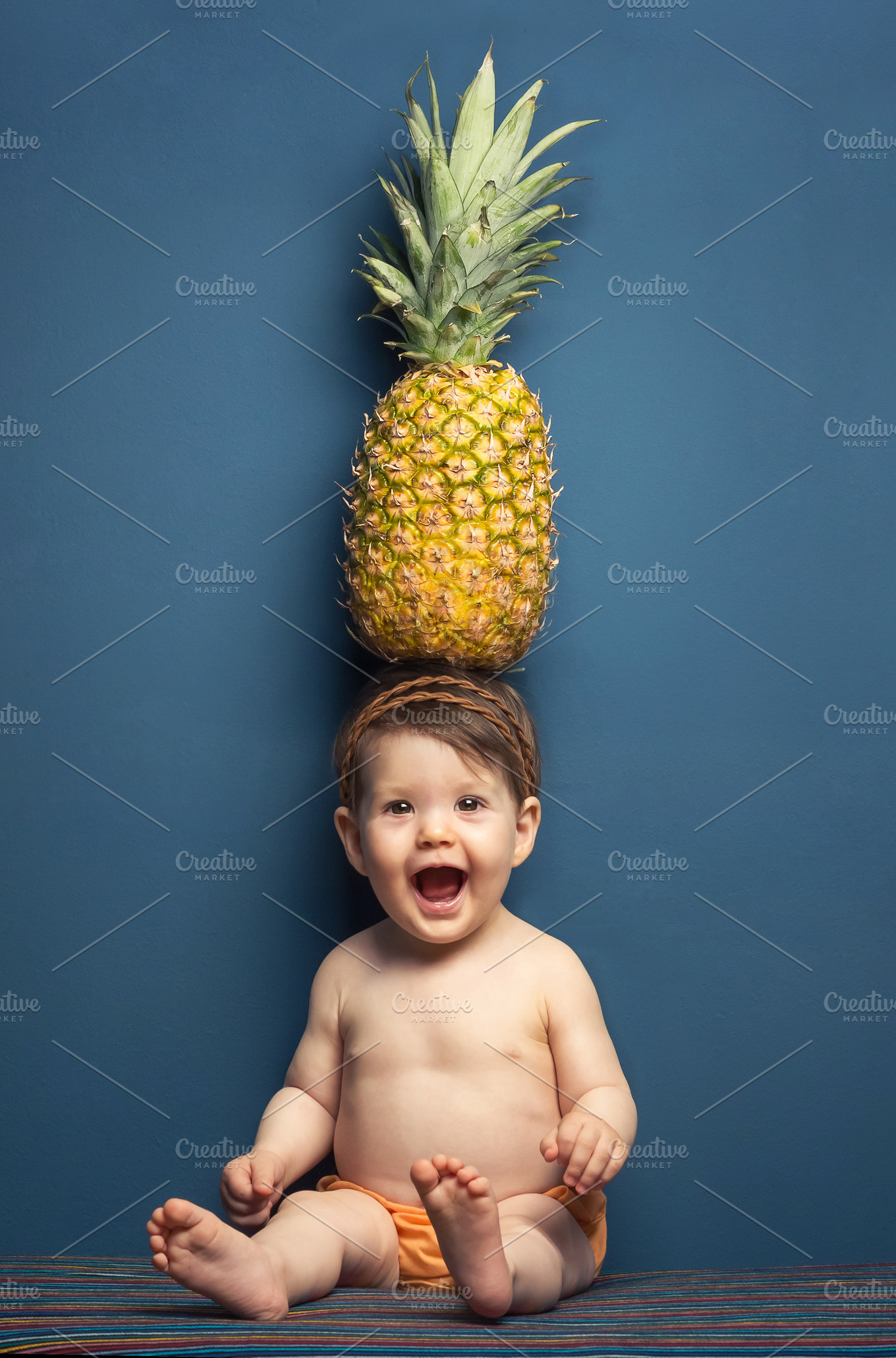 Baby girl holding pineapple in head HighQuality People Images