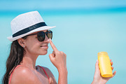 Young woman apply cream on her nose featuring suntan, protection, and ...