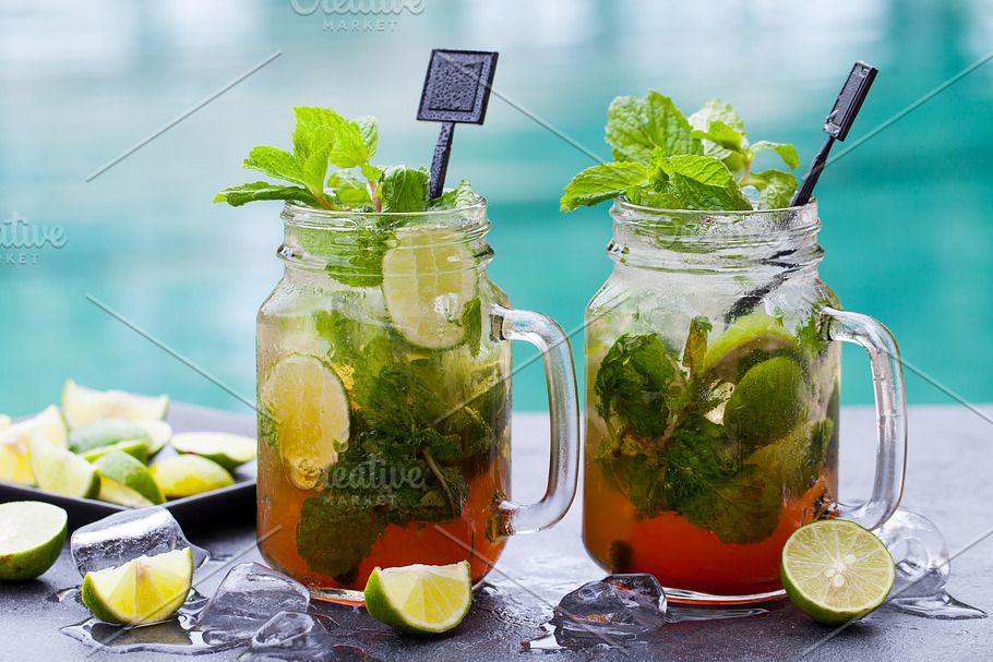 Mojito cocktail with lime and mint in highball glass on a grey stone  background Stock Photo by annapustynnikova