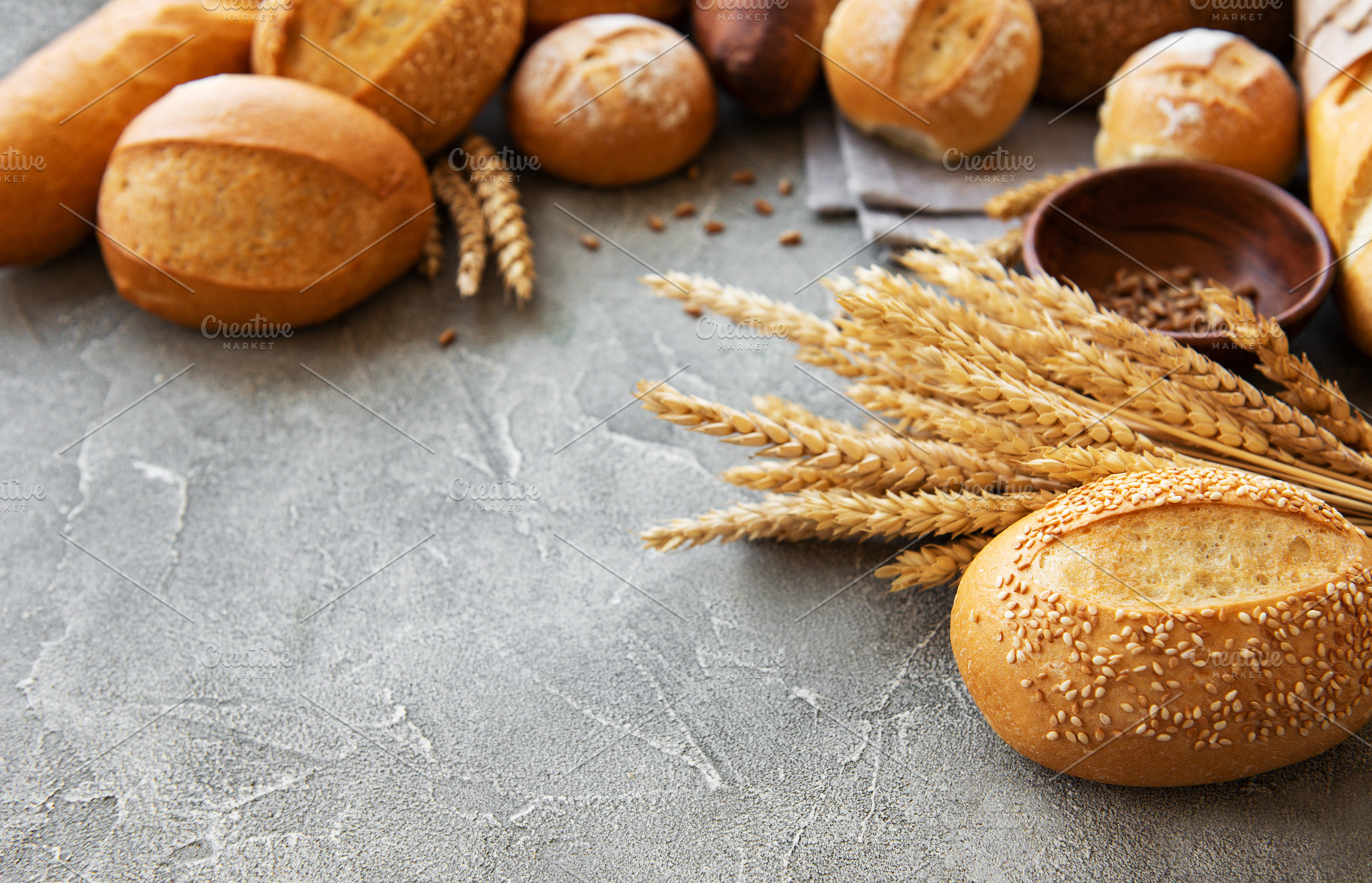 Assortment of baked bread containing bread, background, and wheat