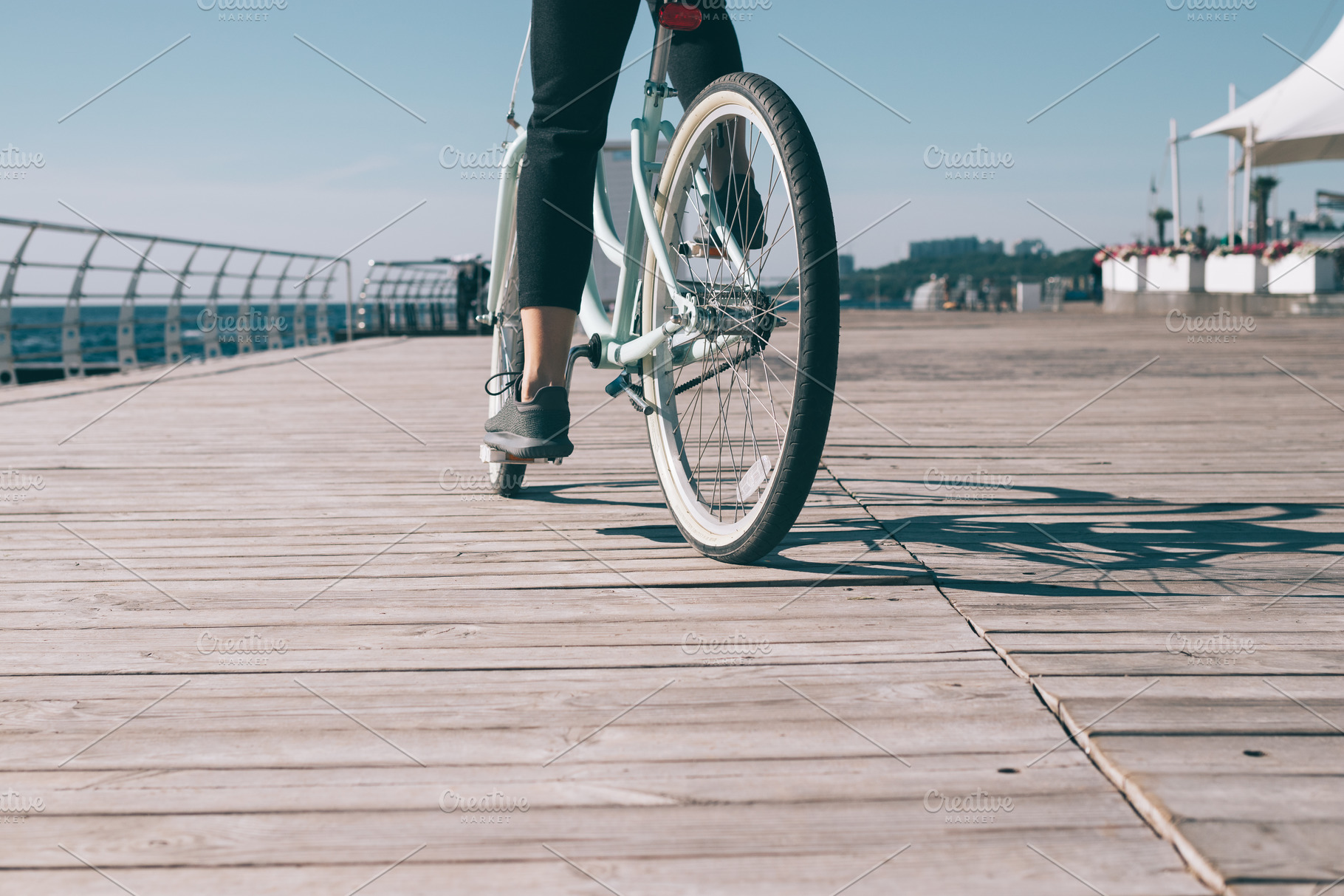 Young woman riding bike on the water | People Images ~ Creative Market