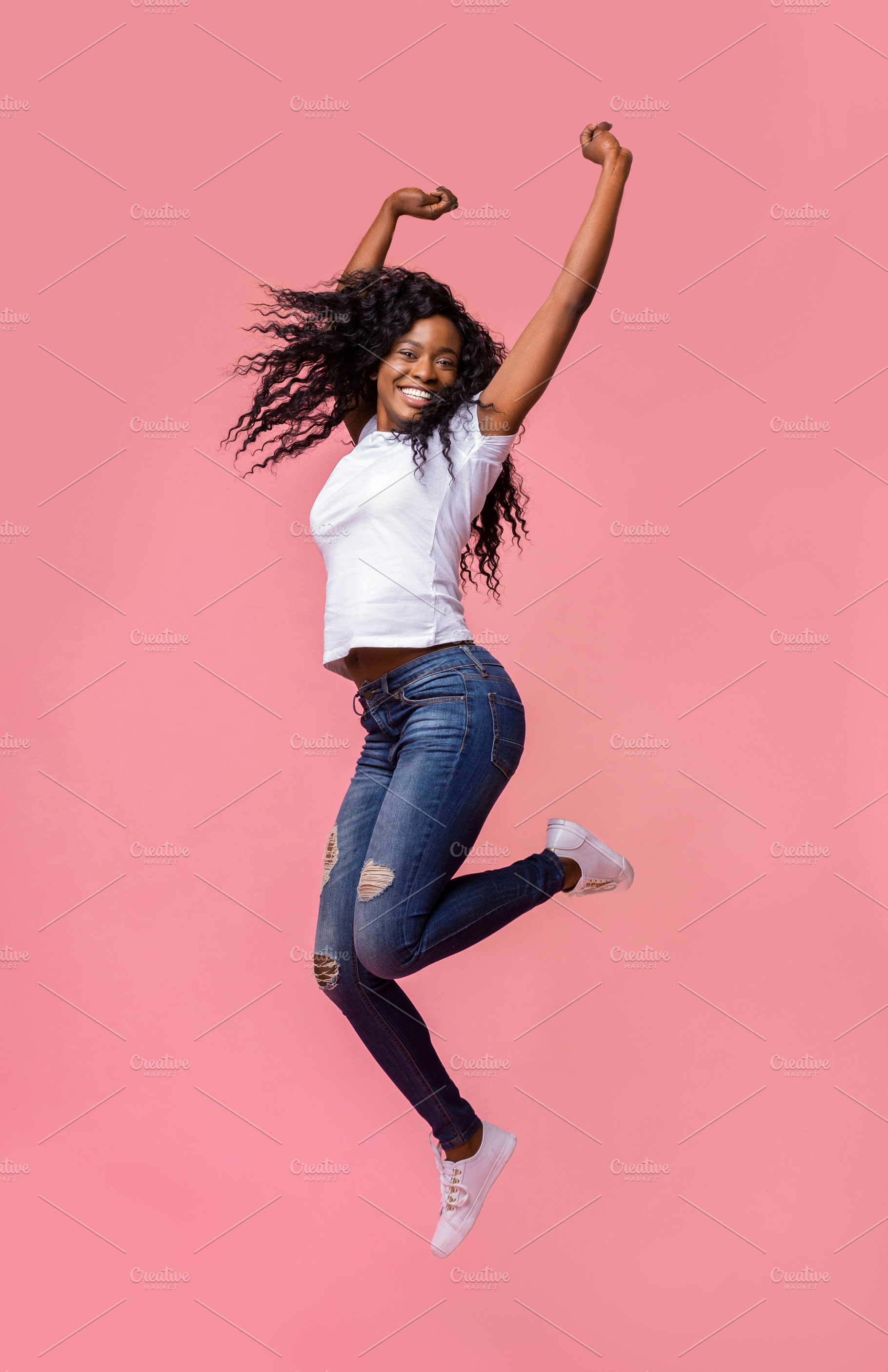 Smiling young african woman jumping | Background Stock Photos