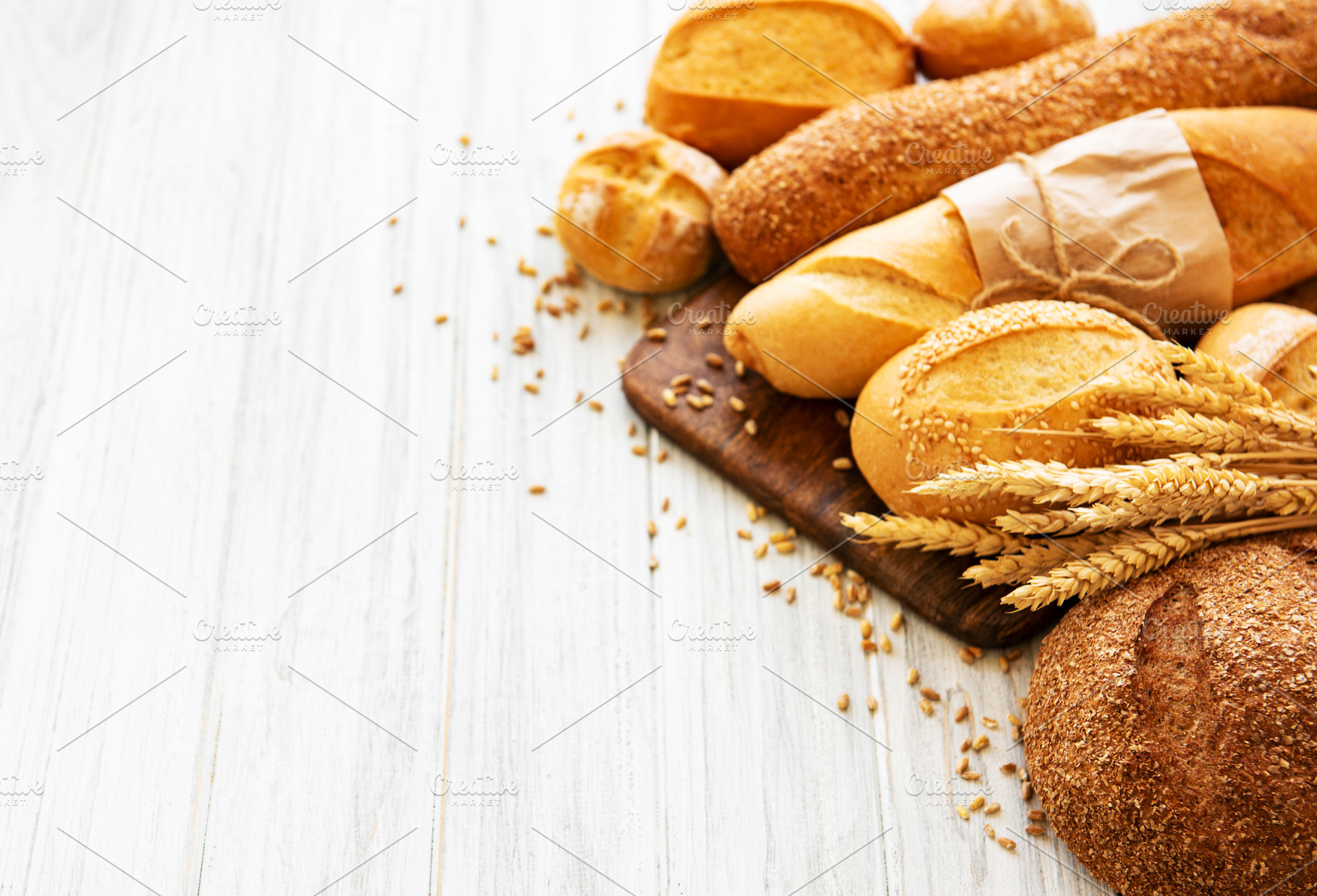 Assortment of baked bread containing bread, background, and wheat